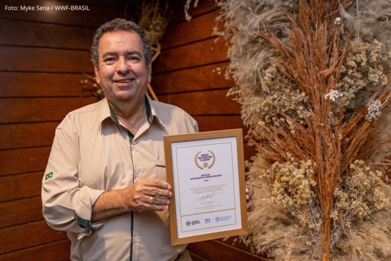 Cláudio Leal, diretor-presidente do IBRAMAR, segura o reconhecimento durante a celebração da Araticum em Brasília.